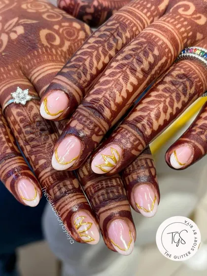 Simple elegance for the modern bride. These nails feature a clean, sheer base with delicate gold leaf patterns painted on the tips, designed to beautifully complement the henna.