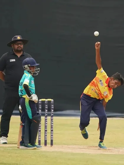 A young bowler in action, his form showing the results of professional coaching and dedicated practice.