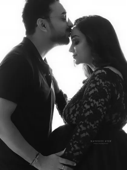 A tender black and white close-up of a husband kissing his wife's forehead. This classic pose is a beautiful expression of love and care.