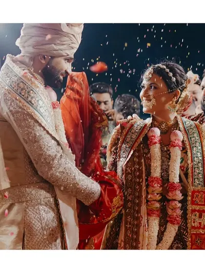 A candid, close-up shot of the couple during the ceremony, capturing a genuine moment of connection amidst the falling petals.
