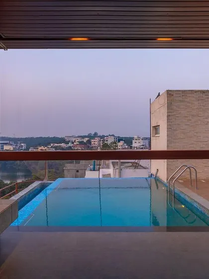 From inside the gazebo, the frameless glass railing provides an uninterrupted view of the infinity pool and the lake beyond. This space is all about relaxation and connection to the horizon.