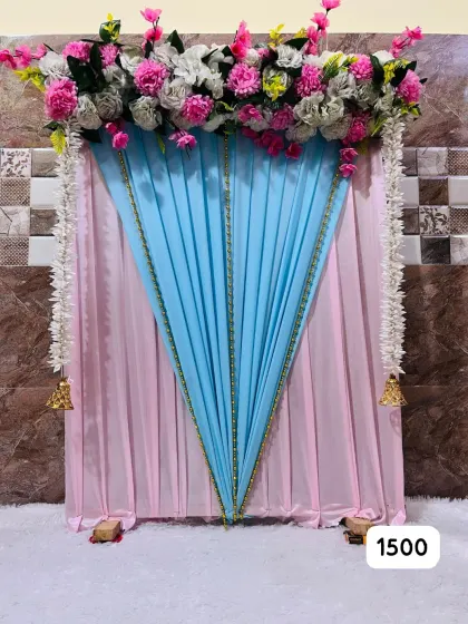 Pink and blue drapes with an artificial-flower header feature in our ready-made Ganpati design advertised at ₹1,500.