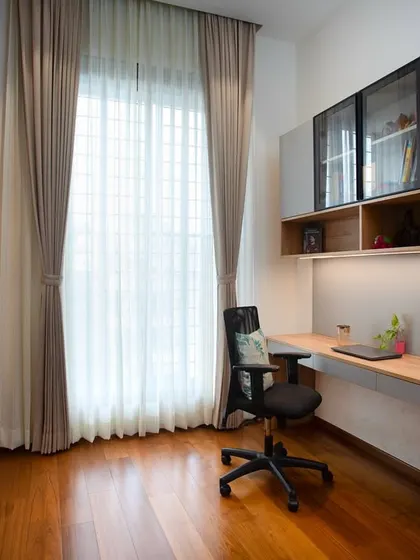 The full view of the home office shows how the natural light from the large window creates a bright and productive environment. The design is a perfect blend of style and functionality.