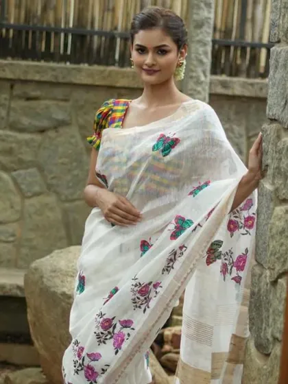 A multi-colored checkered blouse with puff sleeves, shown here with a white linen saree featuring butterfly embroidery. It’s a whimsical and charming look.