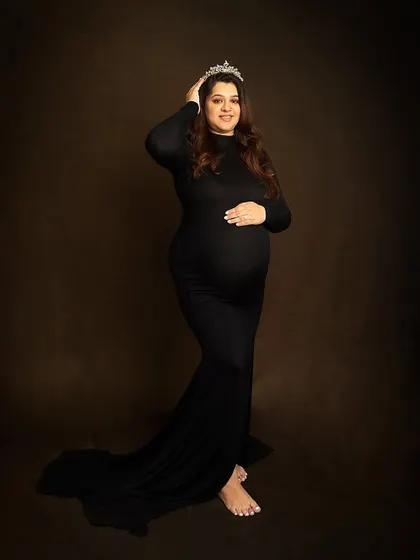Every mother is a queen. A simple tiara adds a touch of royalty to this elegant portrait in a classic black maternity gown.