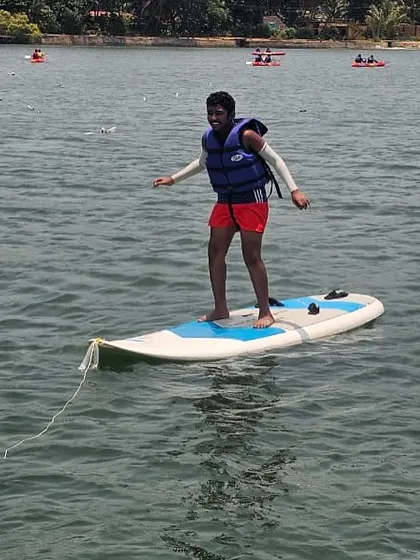 A participant practices balancing on a stand-up paddleboard at our Karwar camp, a foundational skill for many water sports.