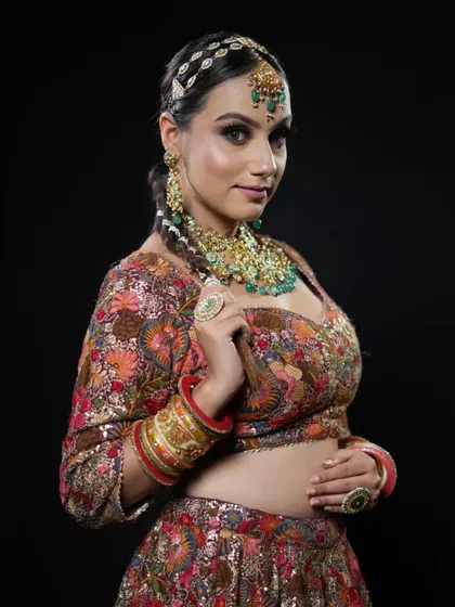 A model showcasing a long, braided ponytail with a traditional matha patti. This is a high-fashion take on a classic bridal hairstyle, perfect for a Mehendi or Sangeet.