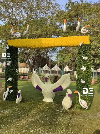 A slightly different angle of the floral swan arch, highlighting the individual bird sculptures and the yellow floral beam. This installation demonstrates my ability to create dynamic, three-dimensional scenes using botanical materials.