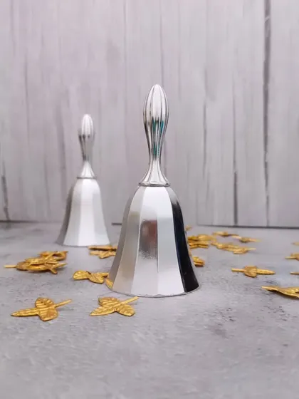 A pair of decorative German silver bells. The sound of the pooja bell is believed to ward off negative energy and invoke divinity.