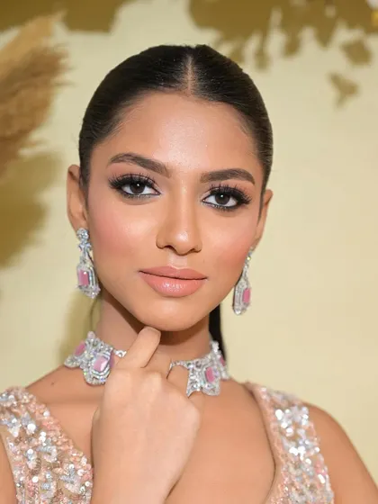 A close-up on the makeup for this brown skin beauty. The focus is on a flawless, sculpted base and a dramatic, sharp-winged eyeliner.