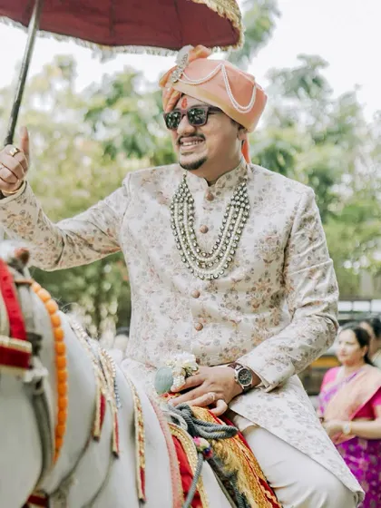 The groom's grand arrival. A classic shot of the baraat, capturing the groom's joy and the festive atmosphere as he makes his way to the wedding.