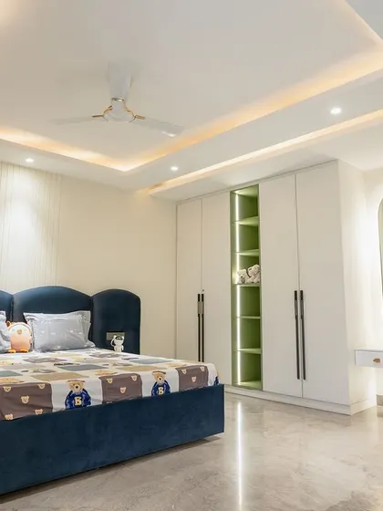 A full view of another kids' room, this one with a navy blue bed and a simple, clean design. The fluted wall panel adds texture and interest.