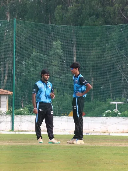 Players have a discussion in the middle of the pitch during a Dasara Cup match.