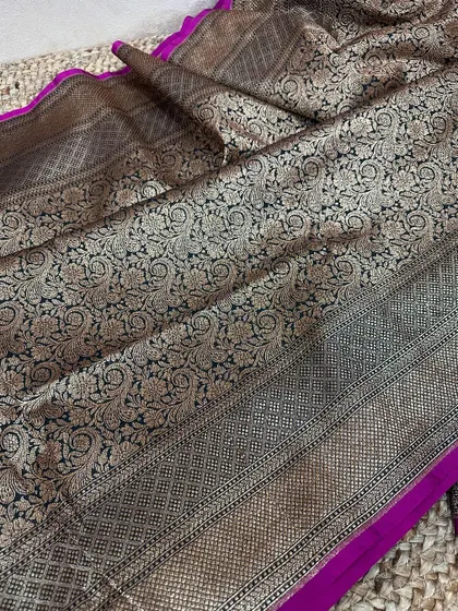Check out the complete look of this black and magenta Banarasi silk saree. The antique gold zari jaal work covers the entire pallu, creating a luxurious effect.