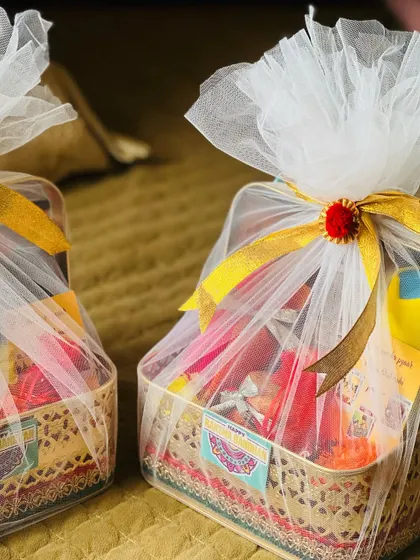 A pair of beautifully wrapped Rakhi hampers in golden baskets, ready for a brother and sister-in-law.