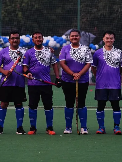 A team in purple jerseys stands together for a photo. We participate in various community events, representing Hockey Navi Mumbai with pride.
