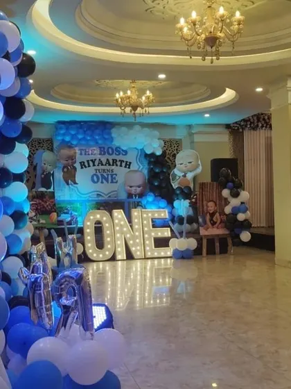 A wide view of a banquet hall decorated for a Boss Baby 'Turns One' party.