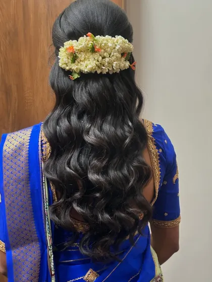 A half-up style with a jasmine gajra, showcasing soft waves that are perfect for a pre-wedding event.