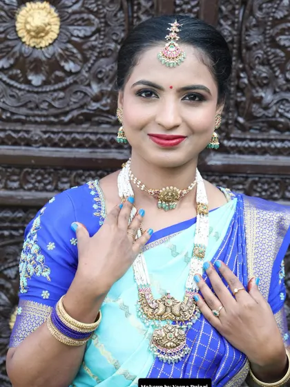 A beautiful guest look against an ornate door. The light blue and royal blue saree is a stunning combination.