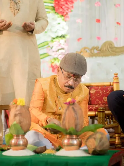 A candid shot of a family member performing rituals during the engagement ceremony, capturing the traditional aspects of the event.