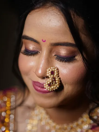 A serene moment. The shimmer on the eyelids catches the light beautifully, adding a touch of magic to this traditional Maharashtrian look.
