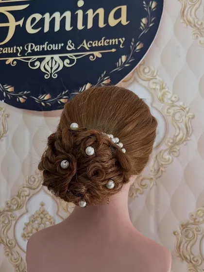 An intricate low bun made of woven hair sections and decorated with scattered pearls. I teach the technique of creating texture and patterns within a bun.