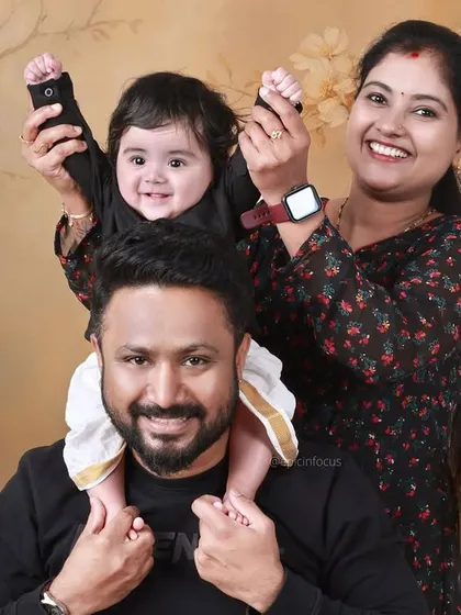 A family portrait with a 'Money Heist' twist. The parents and baby are all smiles, showing that our themed shoots can be fun for the whole family.