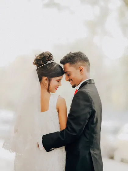 An intimate and classic couple portrait. The focus is on their gentle embrace and happy expressions, creating a timeless memory.