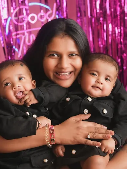 A mother holds her twin babies, her arms full of love. A beautiful portrait celebrating the joy and chaos of life with two.