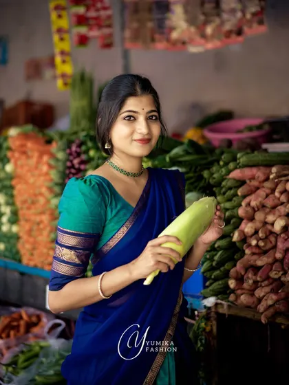 A candid shot in a vegetable market, wearing a blue and green half-saree. This image shows how ethnic wear can be beautifully integrated into daily life.
