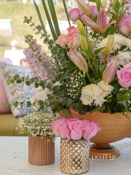 A collection of small floral arrangements in textured gold and copper vases. These were used as part of a larger tablescape, adding layers of detail and warmth.