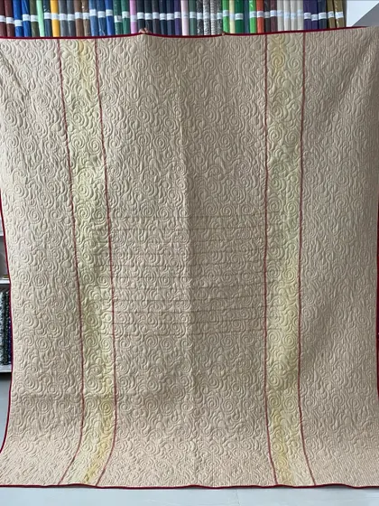 The reverse side of a memory quilt, showing how we use a complementary fabric to create a completely different look. This side features a simple, elegant design that still showcases the intricate longarm stitching.