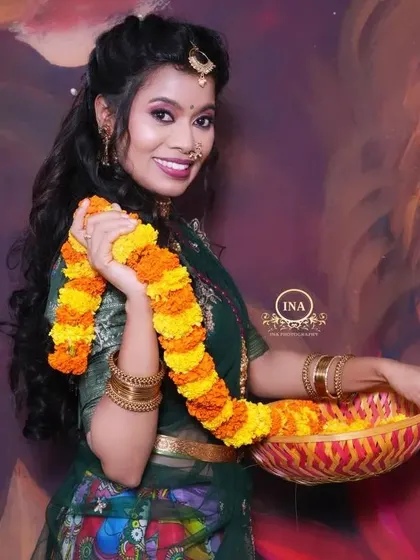 A client looking festive with a basket of flowers, dressed in a green Kalamkari Langa Davani. This outfit is perfect for festival photoshoots.