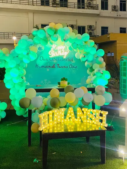 Another night shot of the modern pastel birthday decor, highlighting the glowing 'Happy Birthday' sign and the illuminated name and number.