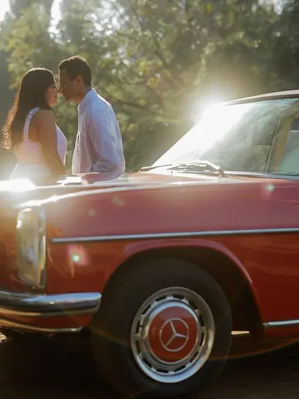 A duplicate of a favorite shot, this image captures the intense sun flare and the intimate connection between the couple, highlighting the cinematic quality of their pre-wedding shoot with the vintage car.