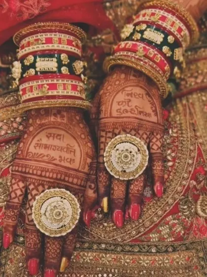 A stunning shot of a bride's hands with traditional blessings written in the mehandi, complete with her bangles and rings.