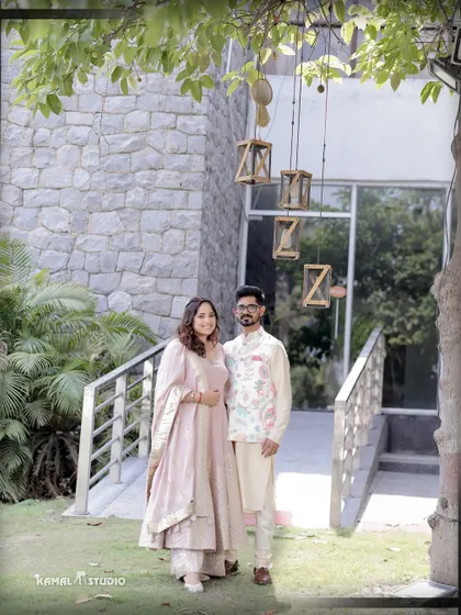 A lovely portrait of the couple standing on a bridge, framed by lush greenery and modern decor.