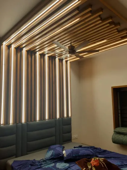 Here’s where minimalist design meets maximum impact. A geometric wood ceiling with integrated light strips creates a cozy, modern flair in this bedroom.