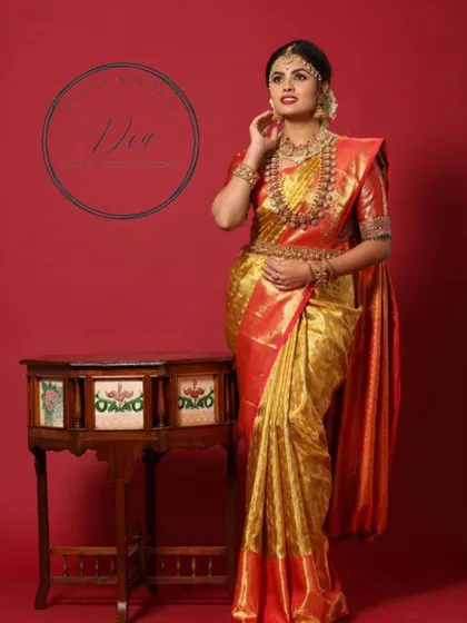 This image captures the grace and elegance of the traditional bridal look. The makeup is designed to look flawless from every angle, enhancing the model's features and complementing the rich attire.
