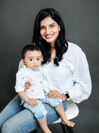 A beautiful mother and son portrait against a classic grey studio background. The clean, simple setup allows their connection and smiles to be the main focus of the photograph.
