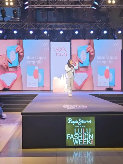 This wide shot shows the stage setup for my talk at Lulu Fashion Week. I use these platforms to educate a broad audience on women's health, discussing topics like cramp relief and the realities of menstruation, which affects us for thousands of hours in our lives.
