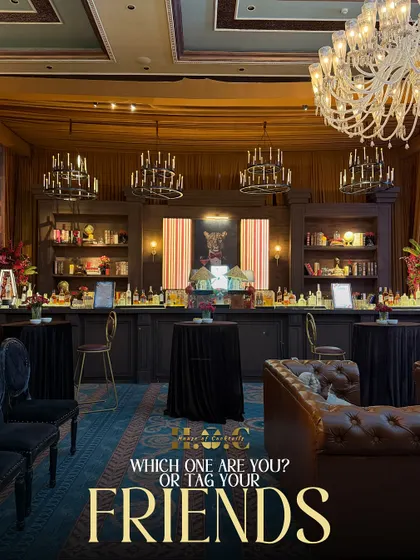 This grand, library-themed bar setup creates a warm and inviting atmosphere. The extensive back bar, leather furniture, and elegant chandeliers make it a perfect spot for guests to gather.