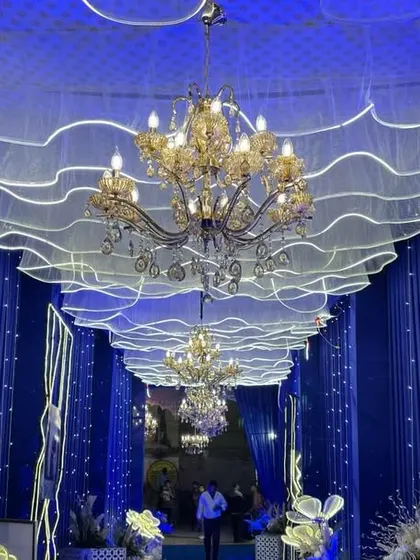 I believe the entrance sets the tone for the whole event. This is a grand entryway I designed, using royal blue drapes, elegant chandeliers, and custom LED lighting to create a magical atmosphere from the moment guests arrive.