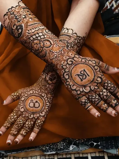 A personalized design featuring the couple's initials 'SM' in a circle on one palm and interlocking rings on the other, symbolizing their union.