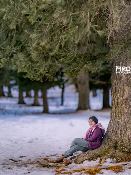 A quiet moment in the snow-covered woods of Kashmir. Capturing my daughter as she rests against a pine tree, a peaceful and beautiful memory from our family trip.