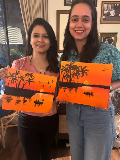 Two more happy artists with their completed sunset silhouette paintings.