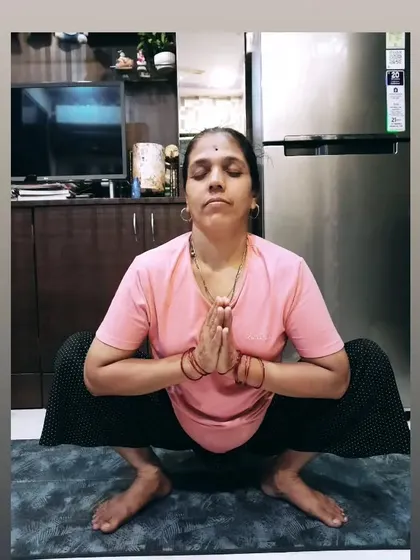 My mom holding Malasana, the Garland Pose. This shows her amazing hip flexibility and grounding, a testament to the benefits of a consistent yoga practice.