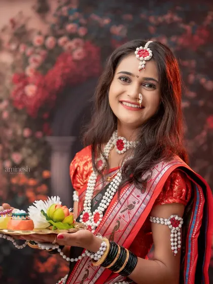 This portrait features a woman holding a festive thali against a beautiful floral backdrop. The soft lighting enhances the warm and celebratory mood of the Sankranti theme.