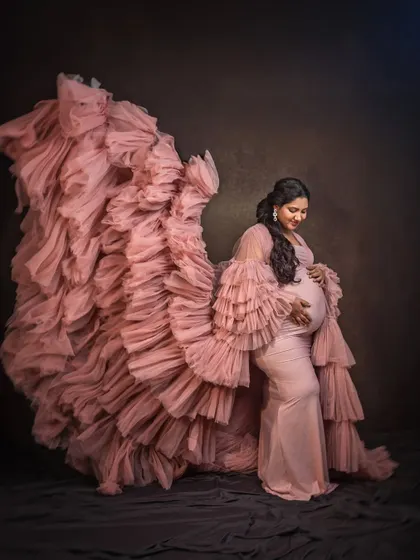 Feel like the queen you are in this flowing pink ruffled gown. In the studio, I use dramatic lighting and posing to create fine art maternity portraits that are both powerful and elegant, celebrating the beautiful form of pregnancy.