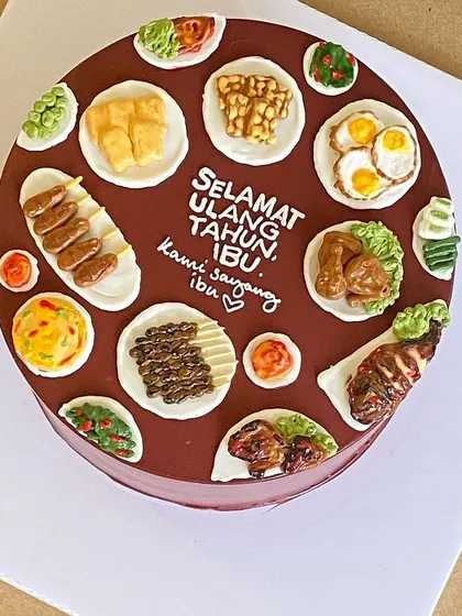 A beautiful cake celebrating a mother's birthday, adorned with her favorite Indonesian dishes like satay and fried rice.